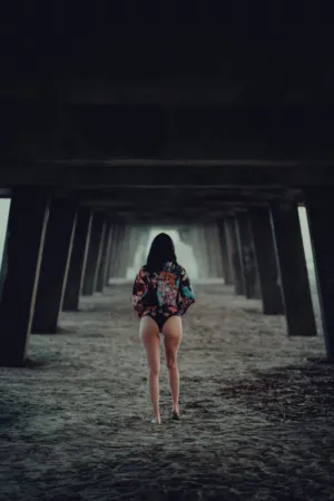 Woman Walking Under A Pier