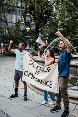 Protestors With 'Silence Is Compliance' Banner