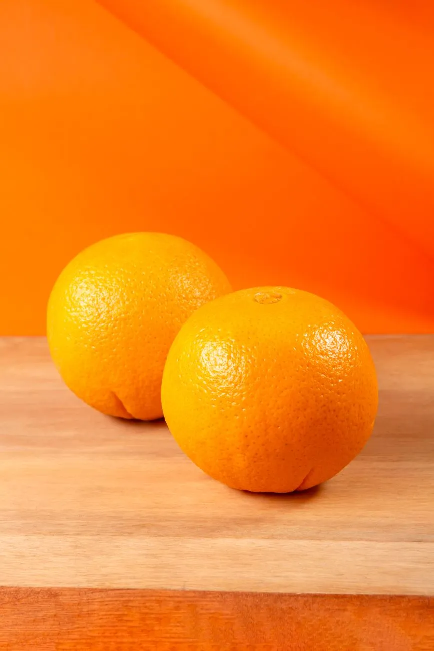 Two Oranges On A Wooden Surface