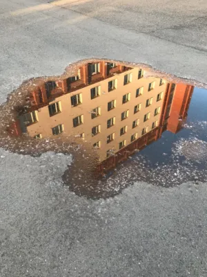 Reflection Of Building In Puddle