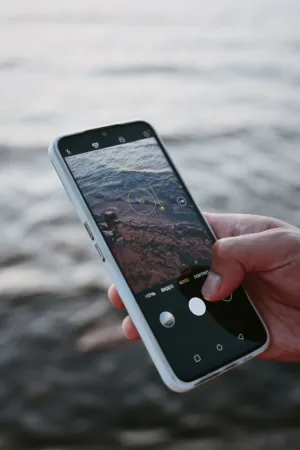 Hand Holding Smartphone With Ocean Background