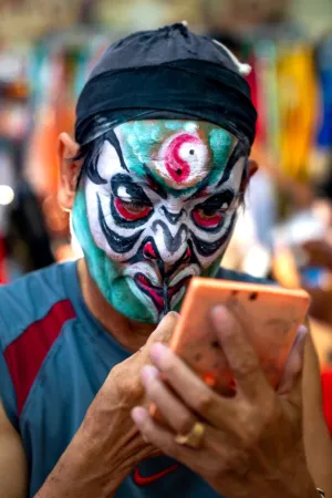 Man With Painted Face Using Phone