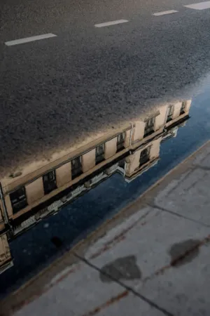 Reflection Of A Building In A Puddle