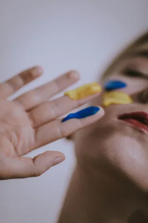 Colorful Paint On Hand And Face
