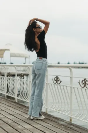 Woman In Black Top And Jeans By Water