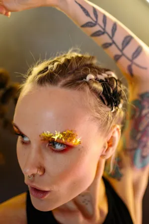Tattooed Model With Braided Hair And Glitter Eyeliner