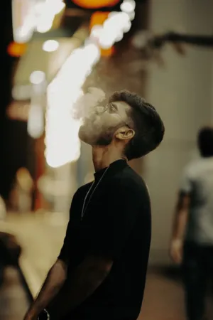 Man In Black Shirt Blowing Smoke