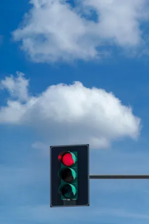 Red Traffic Light Against Cloudy Sky
