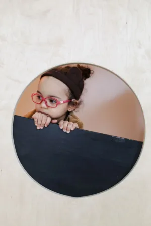 Curious Child Peeking Through A Circular Hole