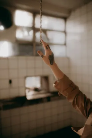 Tattooed Hand Reaching For A Rope