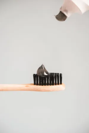 Charcoal Toothpaste On A Wooden Toothbrush