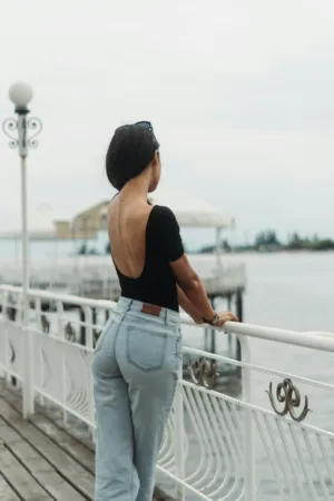 Woman In Black Top And Jeans By Water