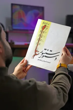 Man Holding A Book With Persian Calligraphy