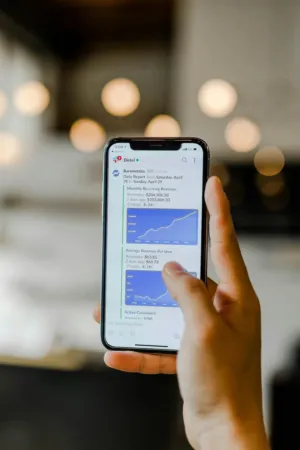 Hand Holding Smartphone With Business Report