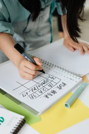 Student Writing In Notebook