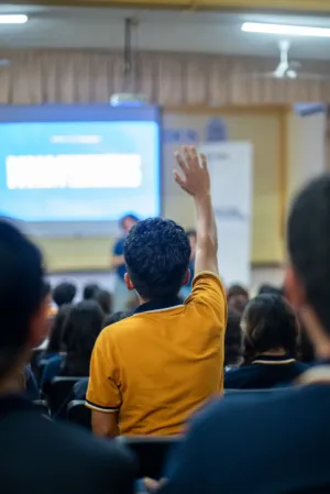 Student Raising Hand In Lecture Hall