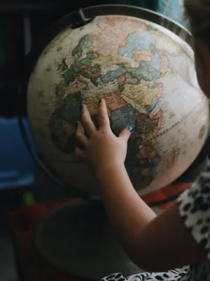 Child Exploring A Globe