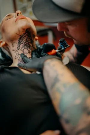 Tattoo Artist Working On Client'S Neck