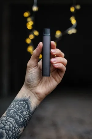 Tattooed Hand Holding A Device