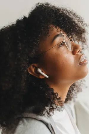 Young Woman With Curly Hair And Earphones