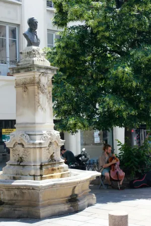 Street Performer In Front Of A Statue