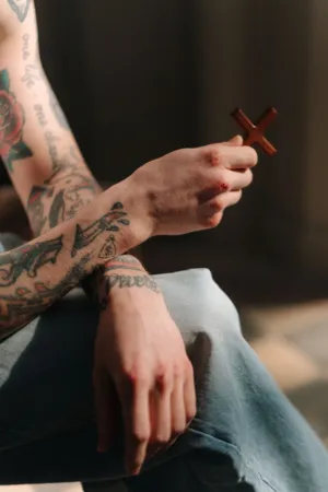 Tattooed Hand Holding A Cross