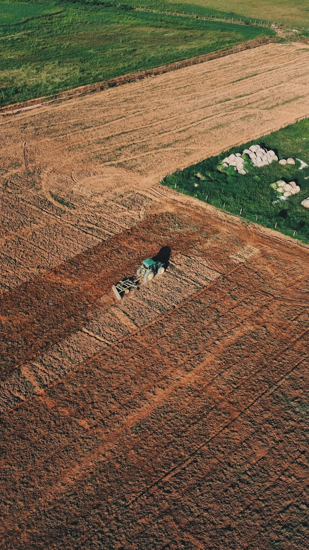 Aerial View Of A Tractor Plowing A Field
