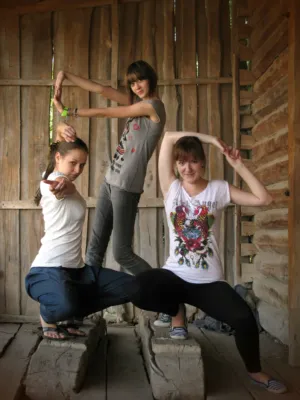 Three Women Posing In Front Of A Wooden Wall