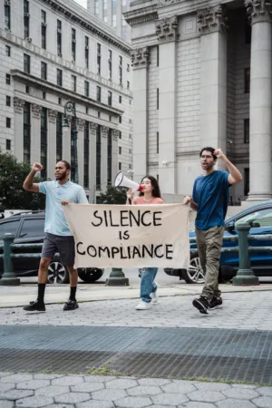 Protestors With 'Silence Is Compliance' Banner