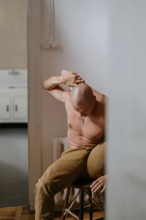 Bare-Chested Man Sitting On A Stool