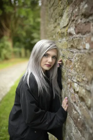 Young Woman Leaning On Stone Wall