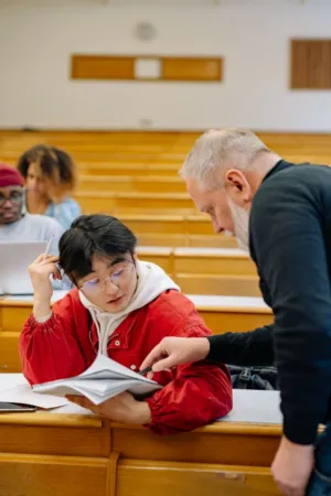 Professor Assisting Student In Lecture Hall