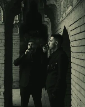 Two Men In Suits Smoking Cigars