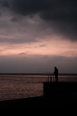 Silhouette Of A Fisherman At Sunset