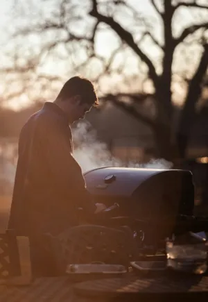 Man Grilling At Sunset