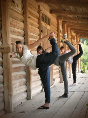 Three Women Practicing Yoga On A Wooden Porch