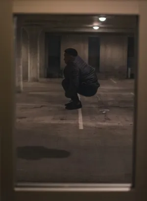 Crouching Figure In Parking Garage
