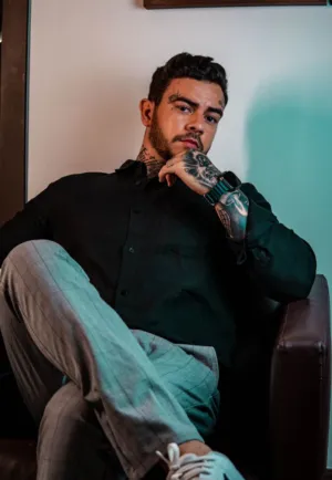 Tattooed Man In Black Shirt And Gray Pants