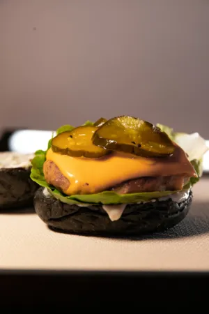 Black Burger With Cheese And Pickles