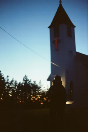 Silhouette Of A Person In Front Of A Church At Sunset