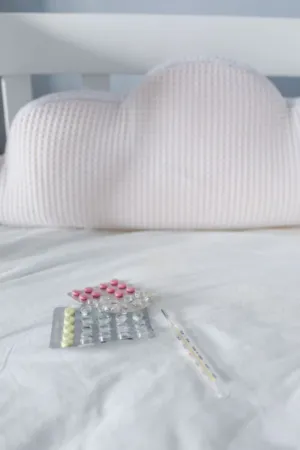 Medication And Thermometer On Bed