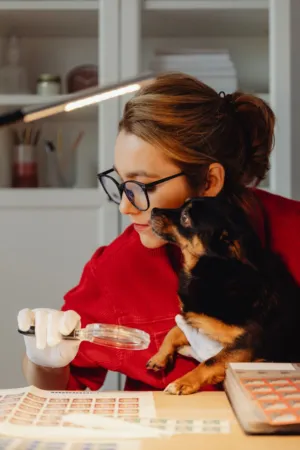 Woman With Dog Examining Stamps
