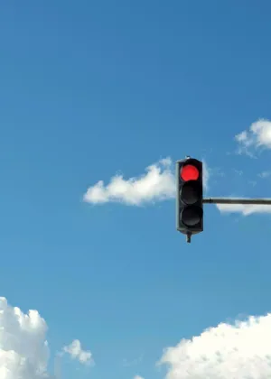 Red Traffic Light Against Blue Sky