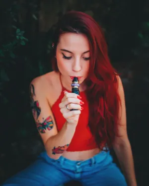 Redhead With Tattoos Smoking An E-Cigarette